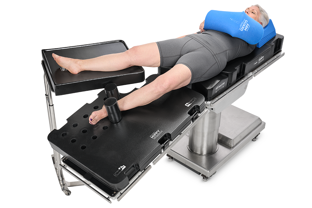 Person lying on a medical examination table with legs secured for a procedure.