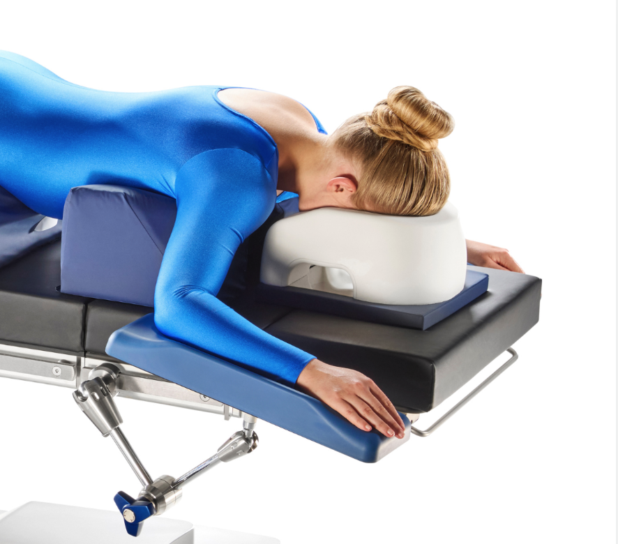 Woman in blue bodysuit lying face down on a massage table.