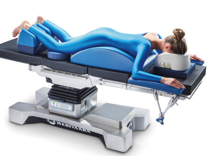 Person in a blue suit lying on a medical examination table.