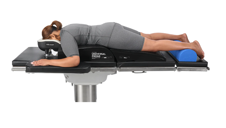 A person lying face down on a medical or therapeutic table.