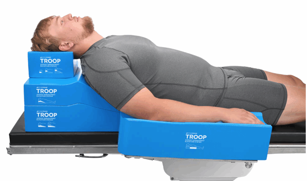 Man lying on a blue medical device labeled TROOP.