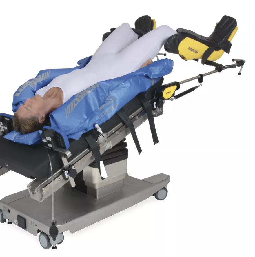 Patient lying on a medical examination table with leg support and monitoring devices.