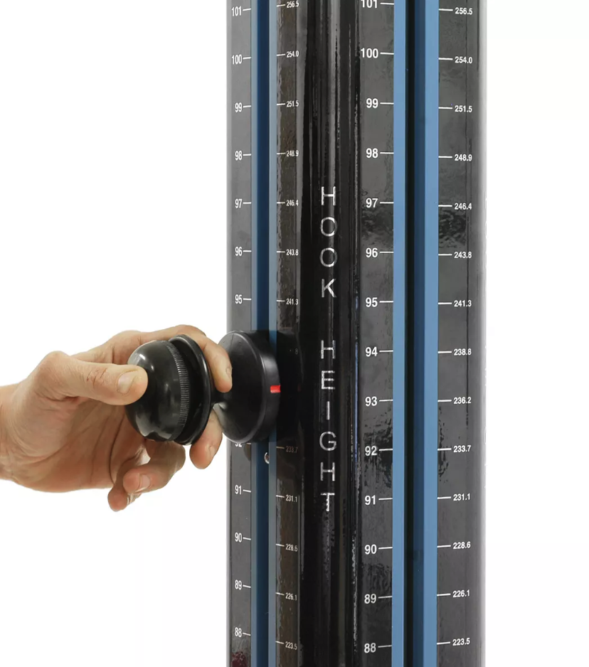 Hand adjusting a hook height on a vertical measuring device.