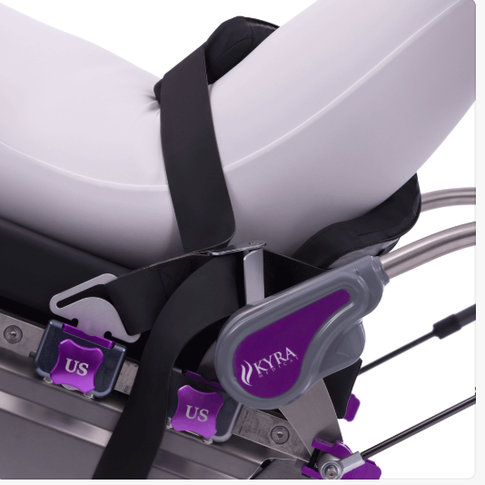 Close-up of a mechanism with purple adjustment knobs on a white cushioned surface.