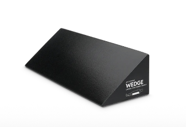 Black triangular wedge cushion for support.