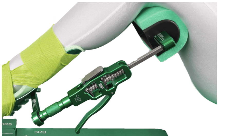 A close-up of a green and white mechanical tool with a trigger and metal rod.