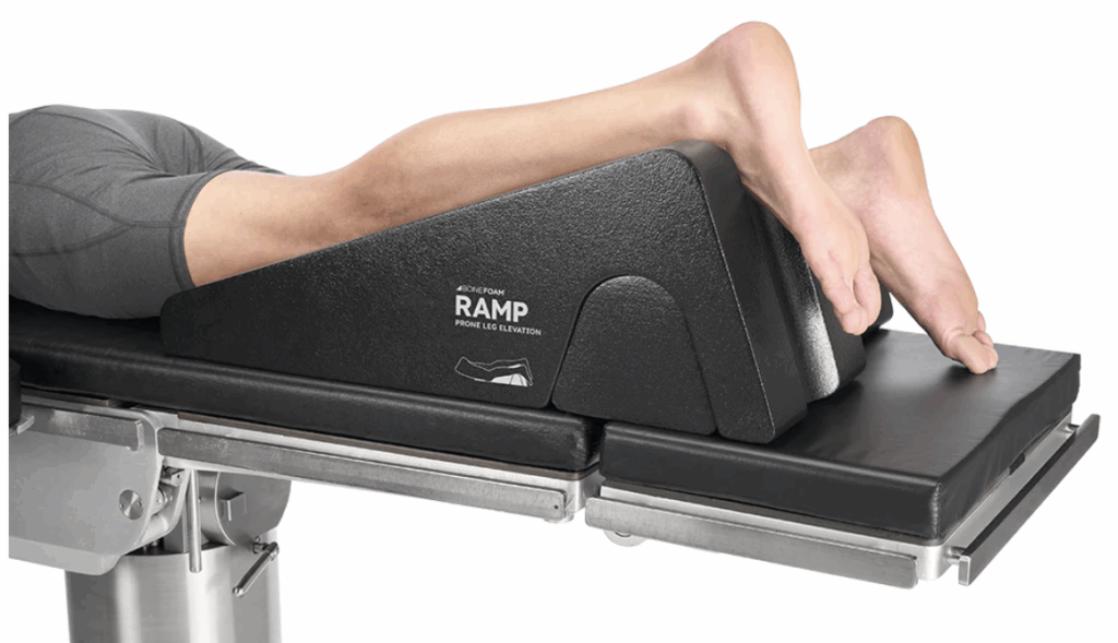 Person using a RAMP shoulder positioning wedge on a medical table.
