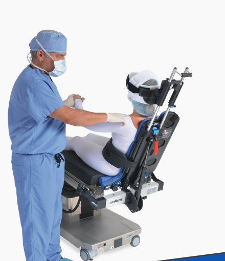 Healthcare professional assisting a patient seated in a medical chair.