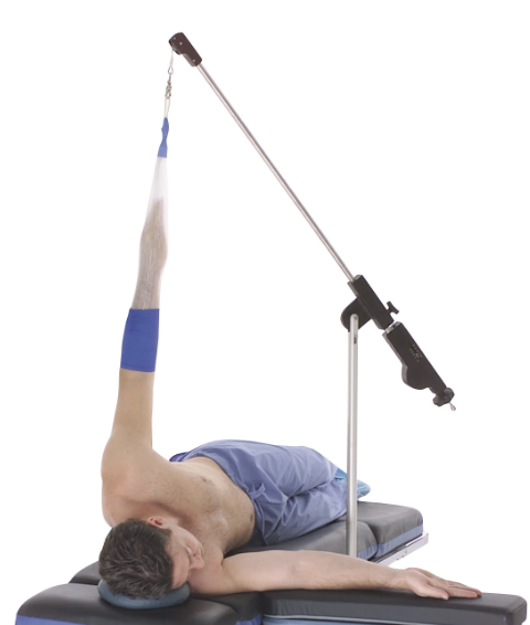 Person performing a pole dance move upside down, gripping the pole with one hand.